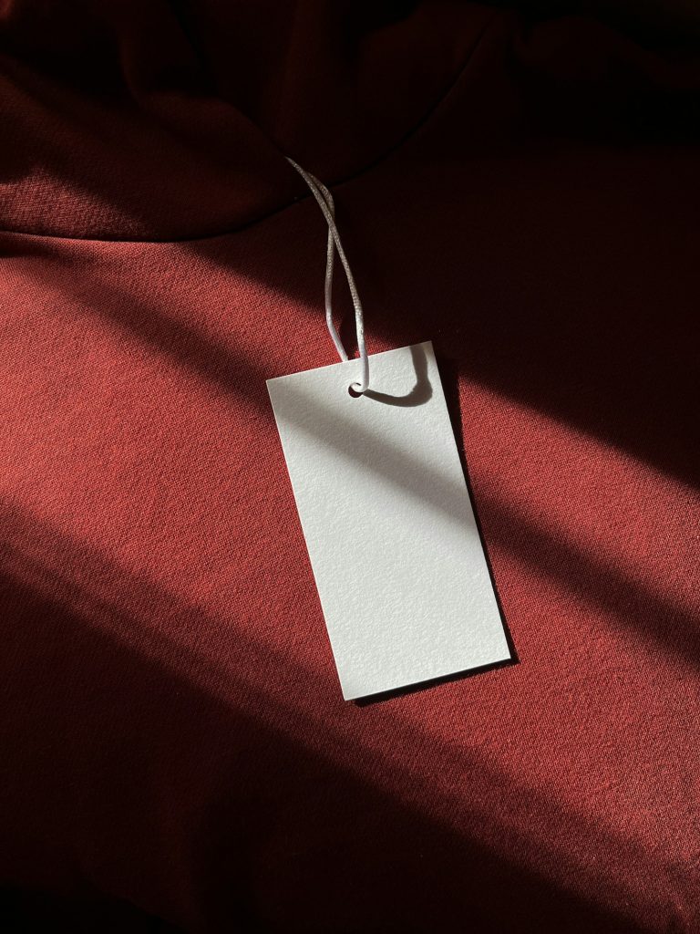 Blank tag hanging on a red garment
