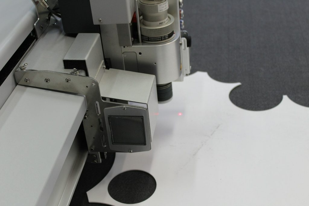 Cutting head of a flatbed plotter cutting a sheet