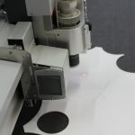 Cutting head of a flatbed plotter cutting a sheet