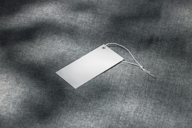 Blank tag lying on grey fabric