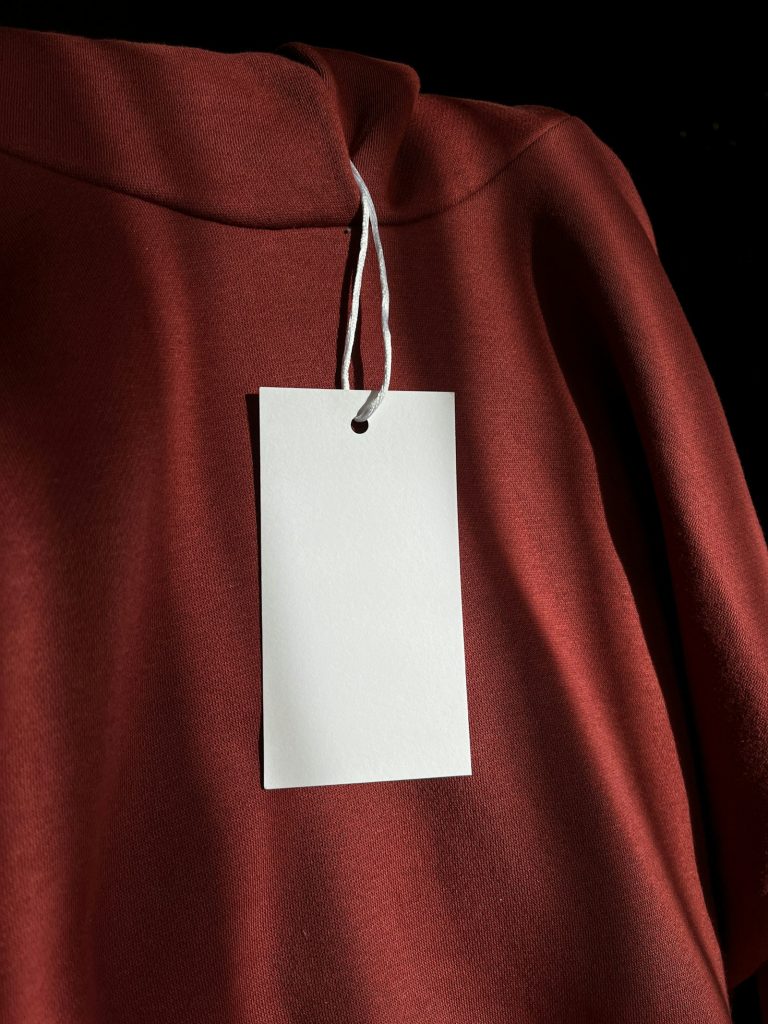 Blank tag hanging on a dark red sweatshirt