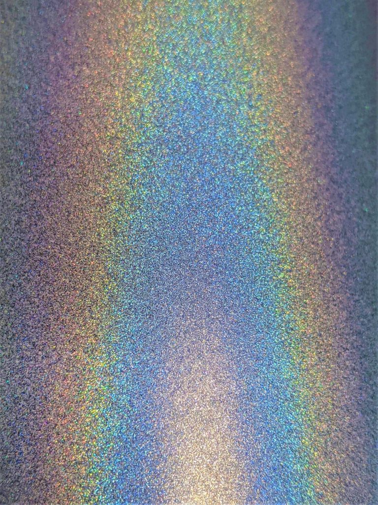 Holographic glitter surface with a rainbow sheen