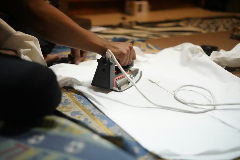 Hand pressing a white t-shirt with a heat tool