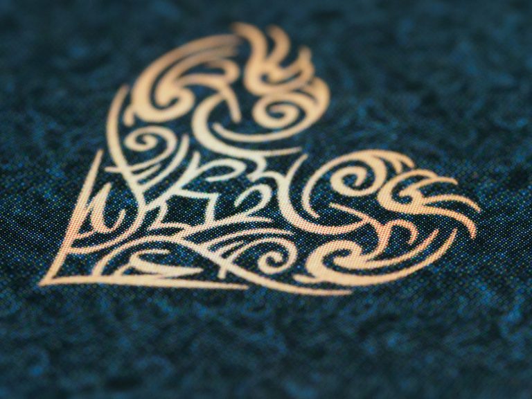 Gold foil ornament stamped on a dark textured surface