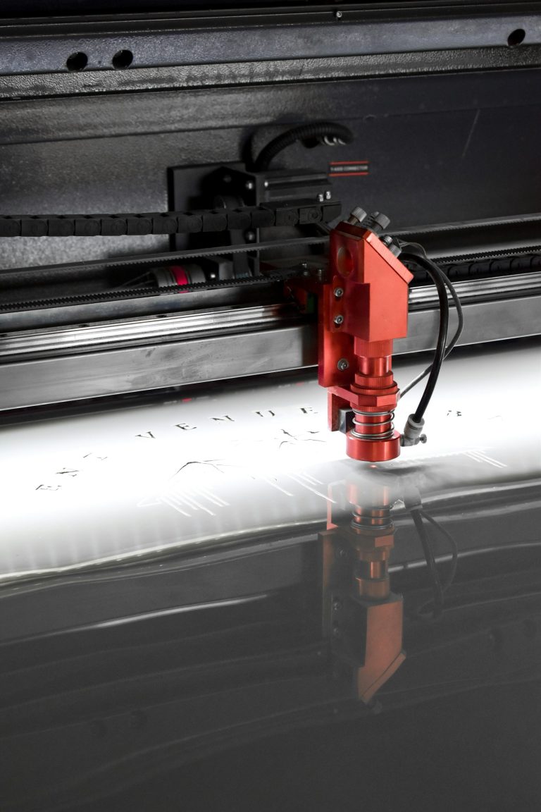 Red cutting head moving over a flatbed cutter