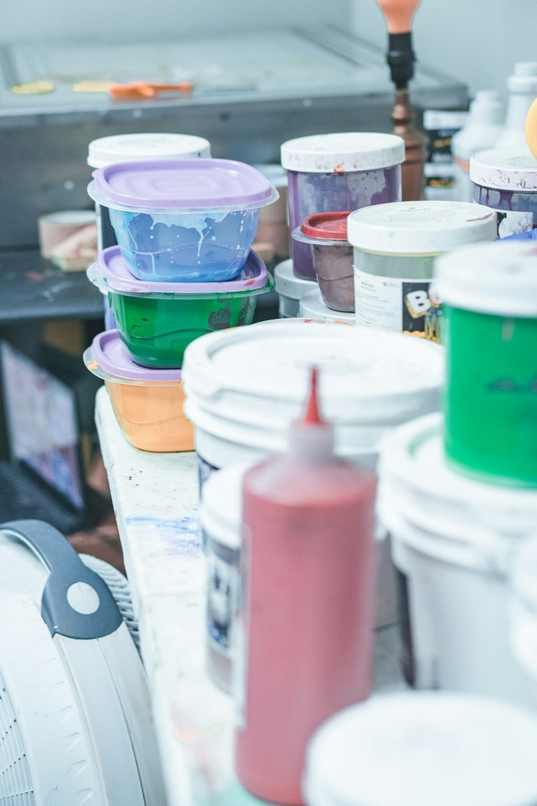 Tubs of coloured ink stacked in a print room